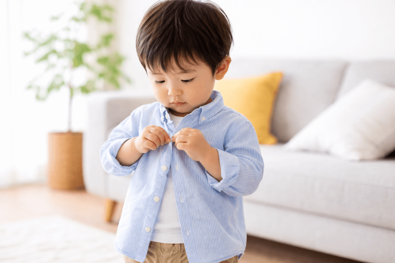 A -two-year-old -child -buttons- his -own- clothes
