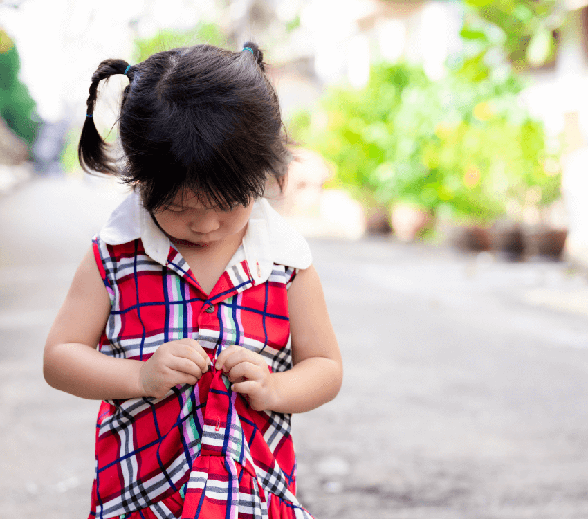 Child- trying -to- button- a- button